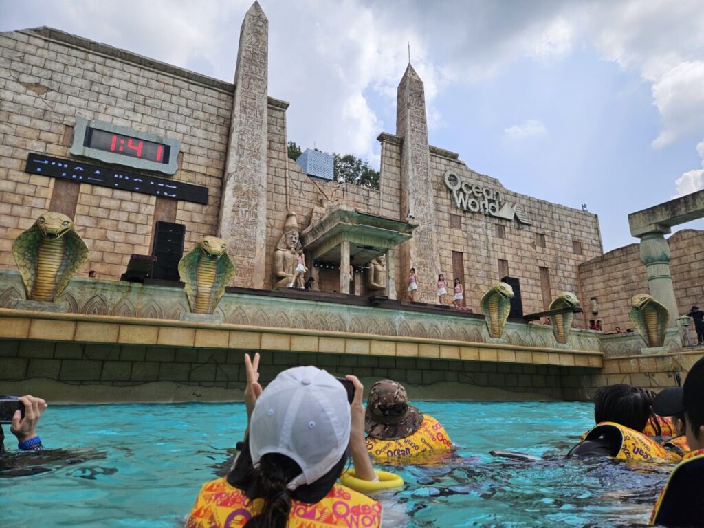 Visitors wearing life jackets enjoying live show at wave pool stage in Ocean World Korea