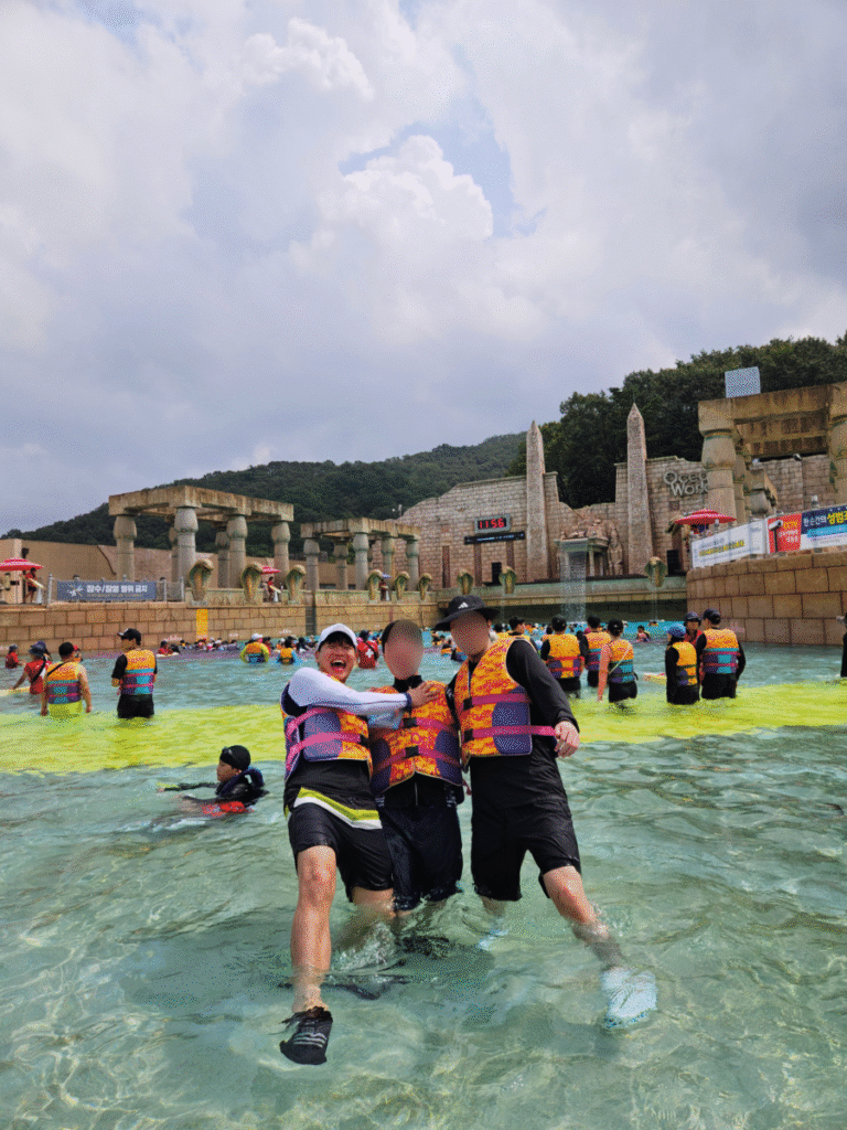 Group of visitors enjoying the wave pool stage at Ocean World Korea, known for K-pop music and dance shows