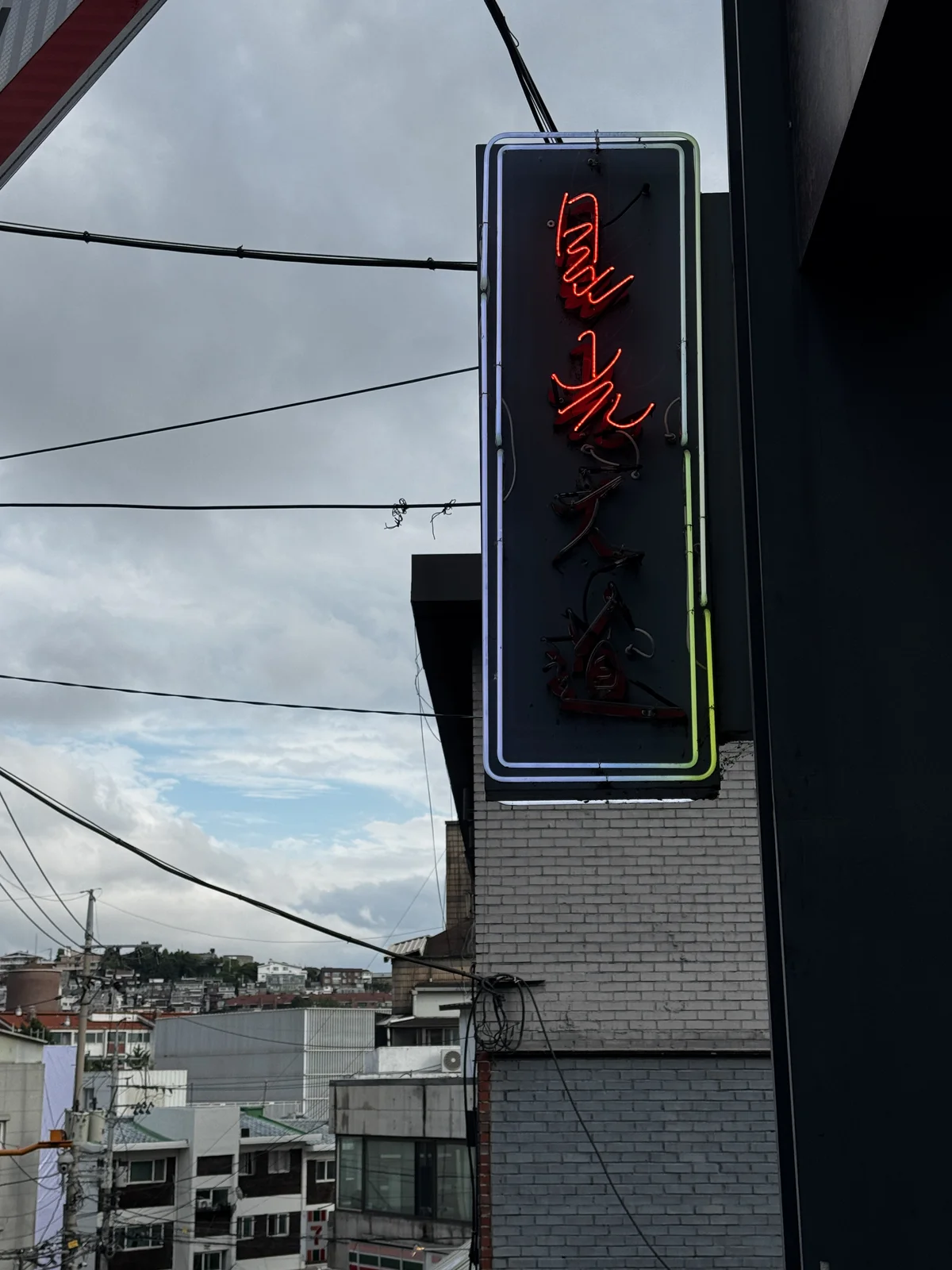 Seonggwangdaedo's neon sign above the basement entrance in Haebangchon, Seoul
